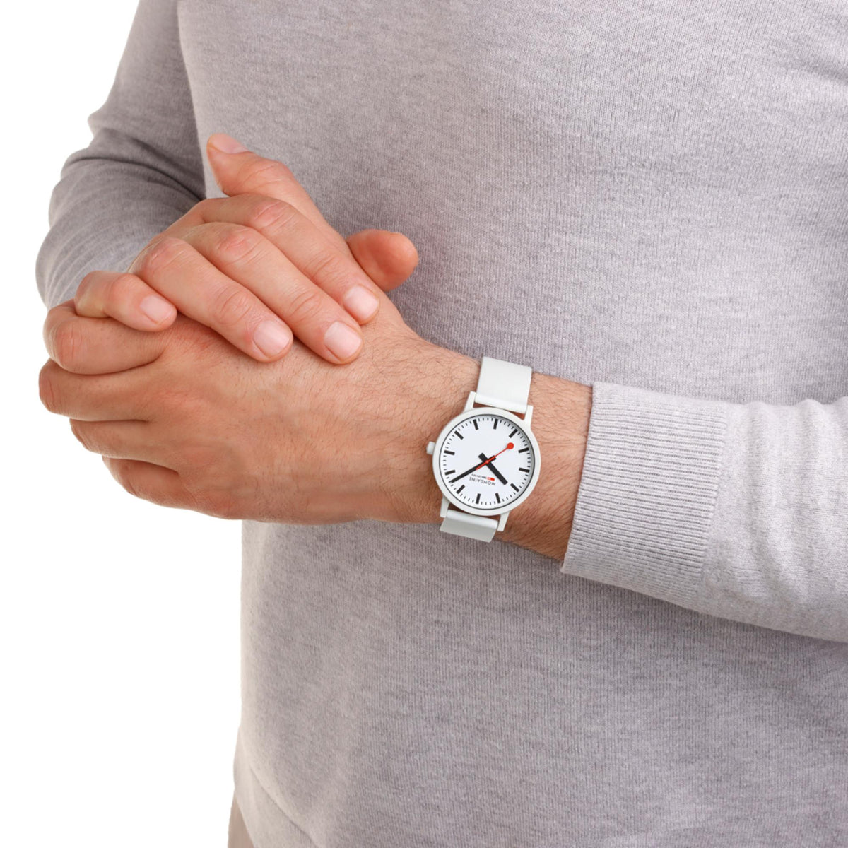 Mondaine Essence wristwatch worn: white dial, black indices, red hands, white silicone strap
