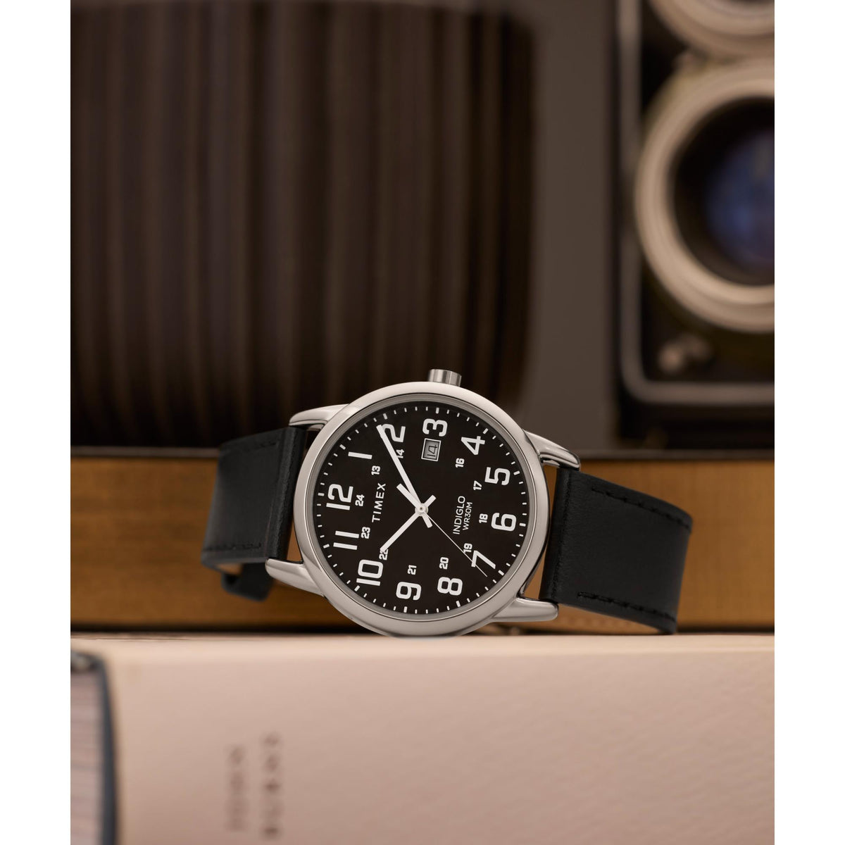 Men's quartz watch with black dial and black leather strap, angled view