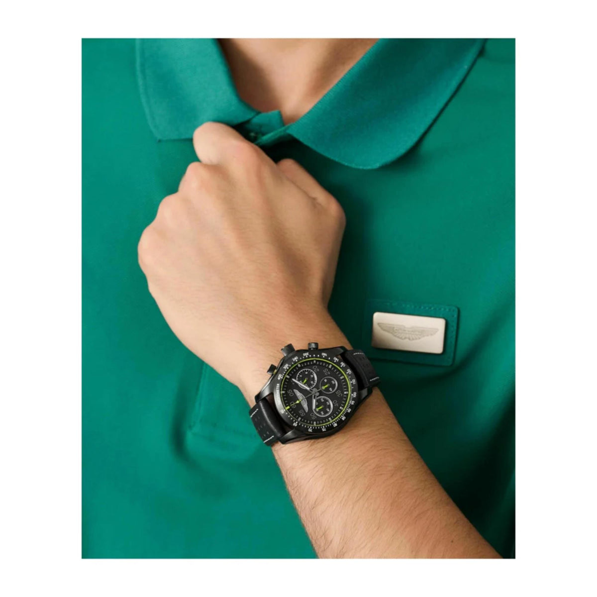 Black leather chronograph watch on wrist with black dial and neon-yellow accents