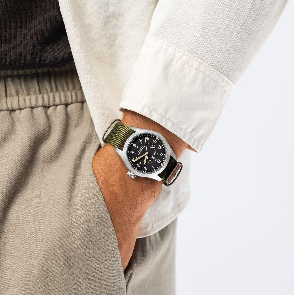 Hamilton Khaki Field H69509930 mens mechanical watch worn on wrist showing black dial, matte stainless steel case, and green fabric strap