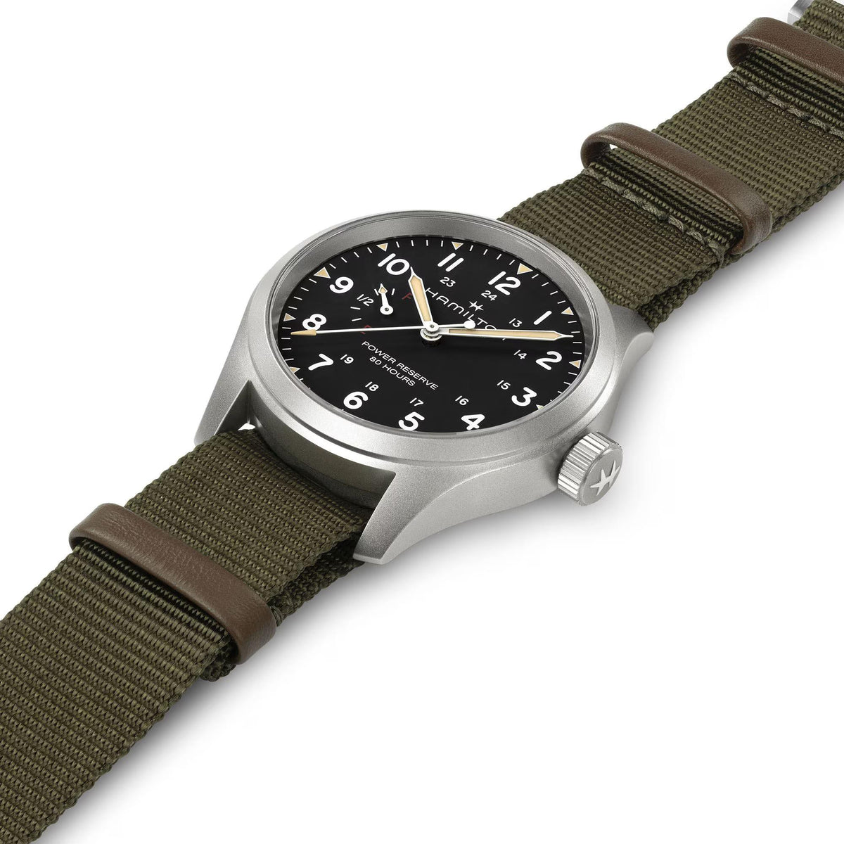 Hamilton Khaki Field H69509930 mechanical watch angled studio view showing black dial, luminous hands, and green textile strap
