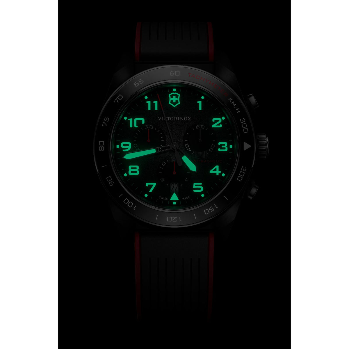 Black dial chronograph watch with green glowing hands and markers, rubber strap