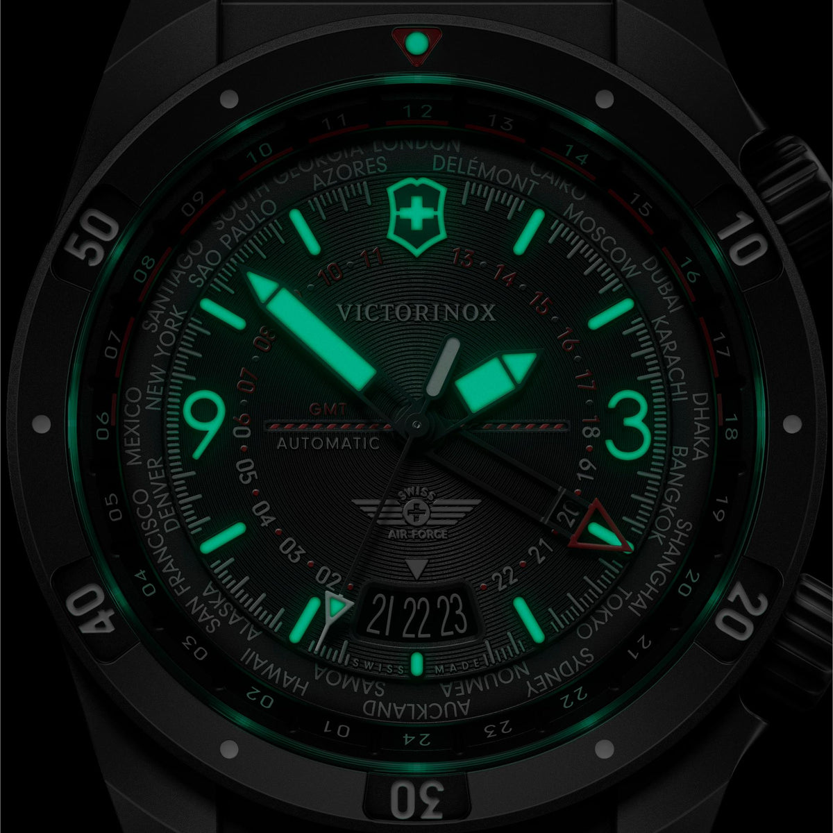 Men's automatic GMT watch close-up with green-luminous black dial, black case and bezel