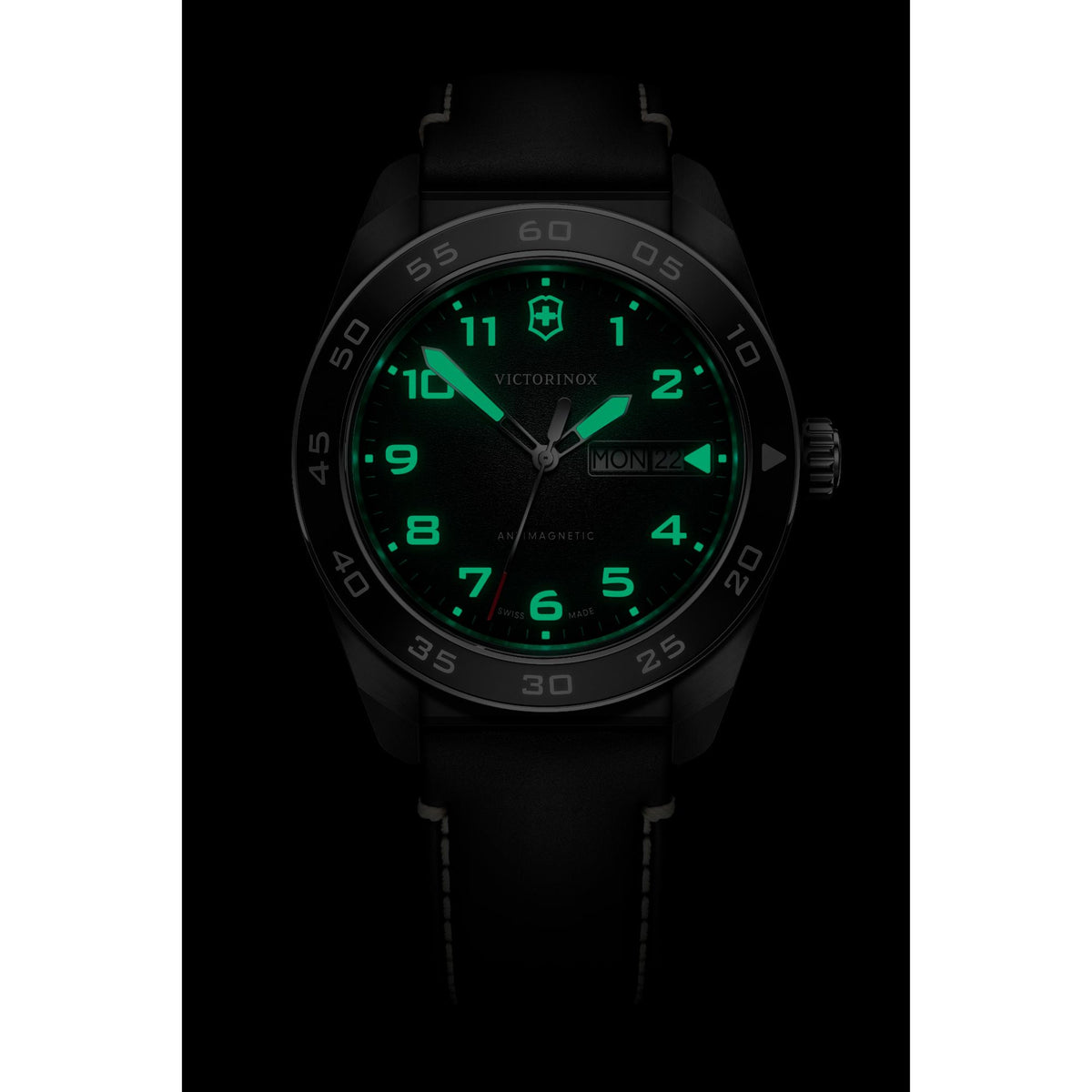 Mens black quartz watch on wrist with green luminous dial and markers