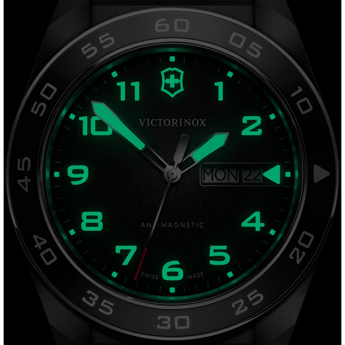 Close-up of mens black dial quartz watch showing green luminous numbers and hands