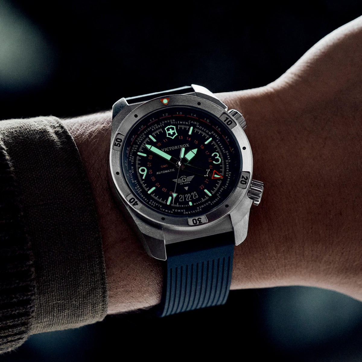Victorinox Air Pro 242003 GMT watch worn on wrist in low light showing glowing luminous hands and markers