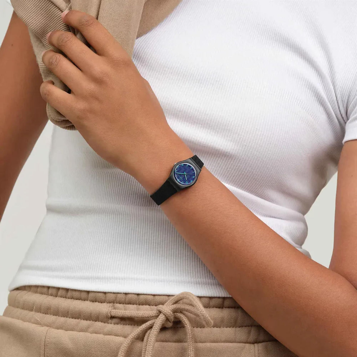 Quartz watch with blue dial and black silicone strap worn on forearm