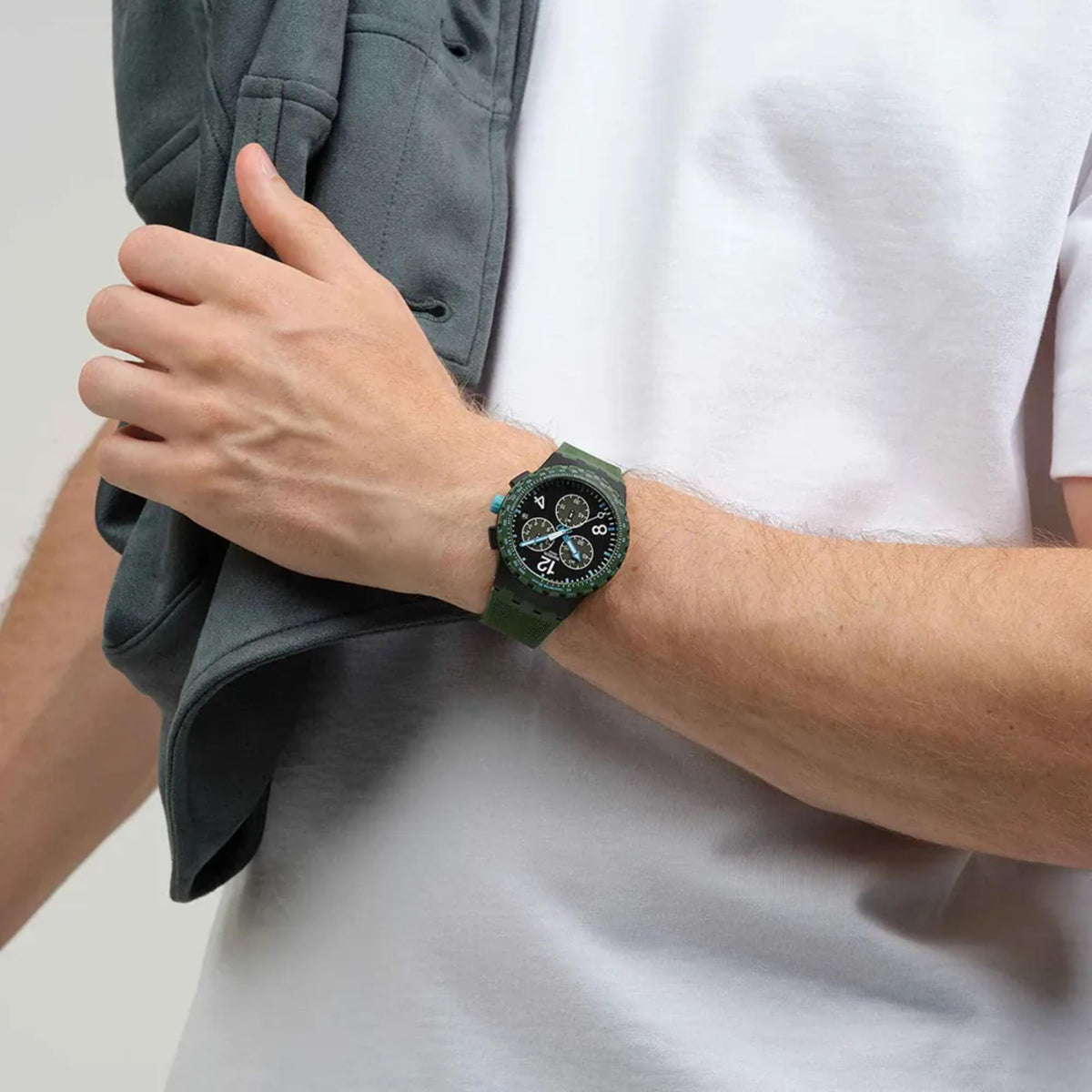 Chronograph watch with green silicone strap and dark dial on wrist