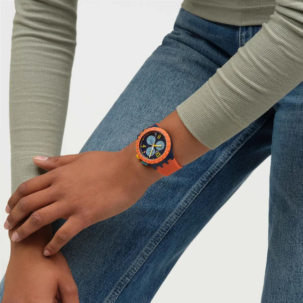 Swatch flash chronograph watch on arm, orange silicone strap with blue dial