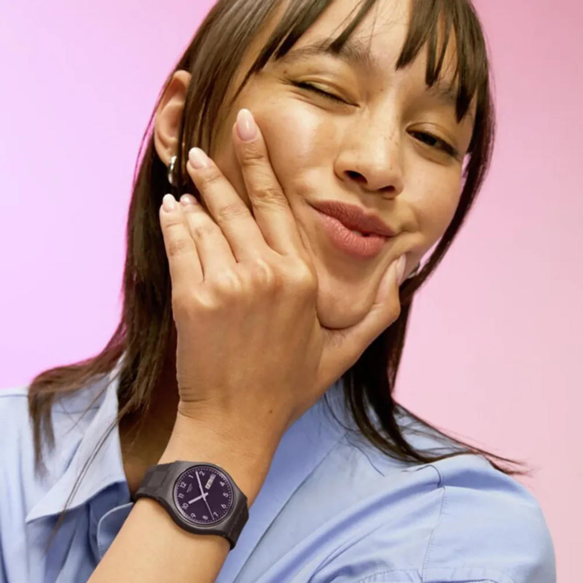 Purple-dial silicone-strap wristwatch worn on a person’s wrist