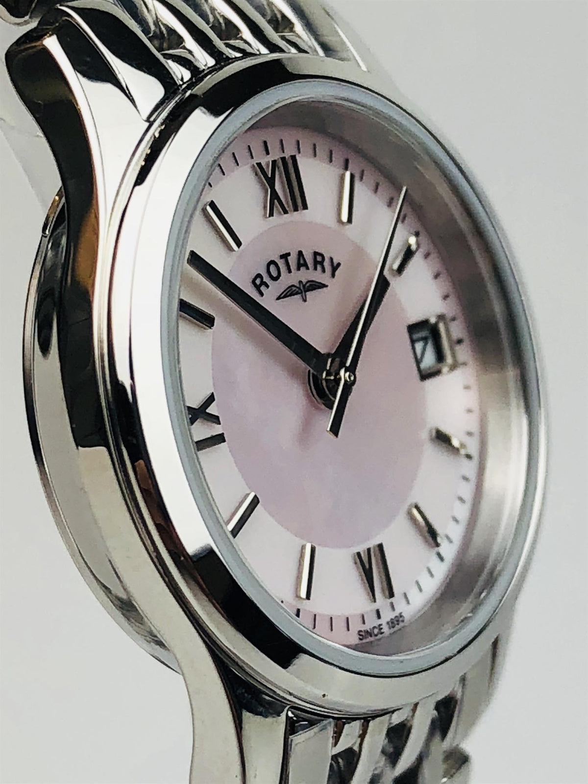 Stainless steel ladies watch close-up with mother-of-pearl dial, Roman numerals, and link band