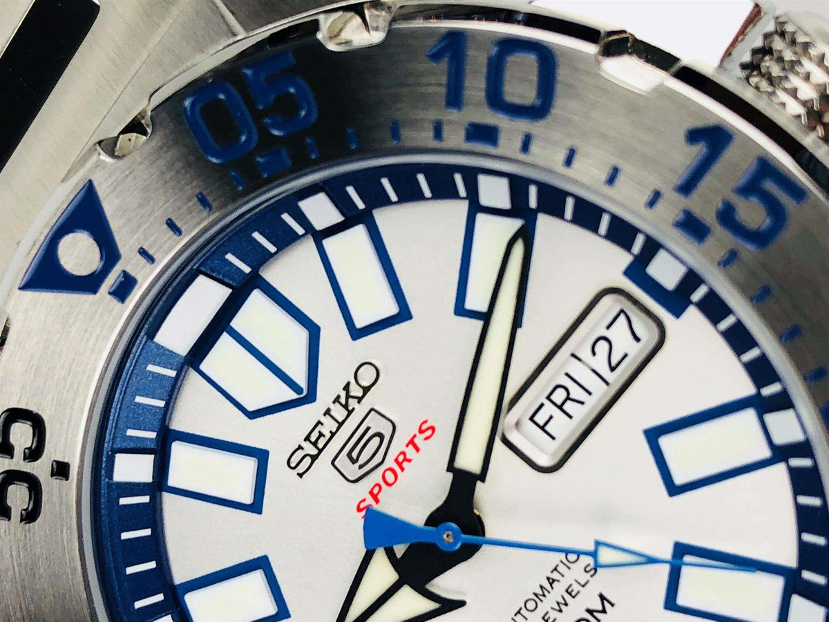 Men's Seiko sports watch close-up of dial, blue bezel markers, FR I27 date window