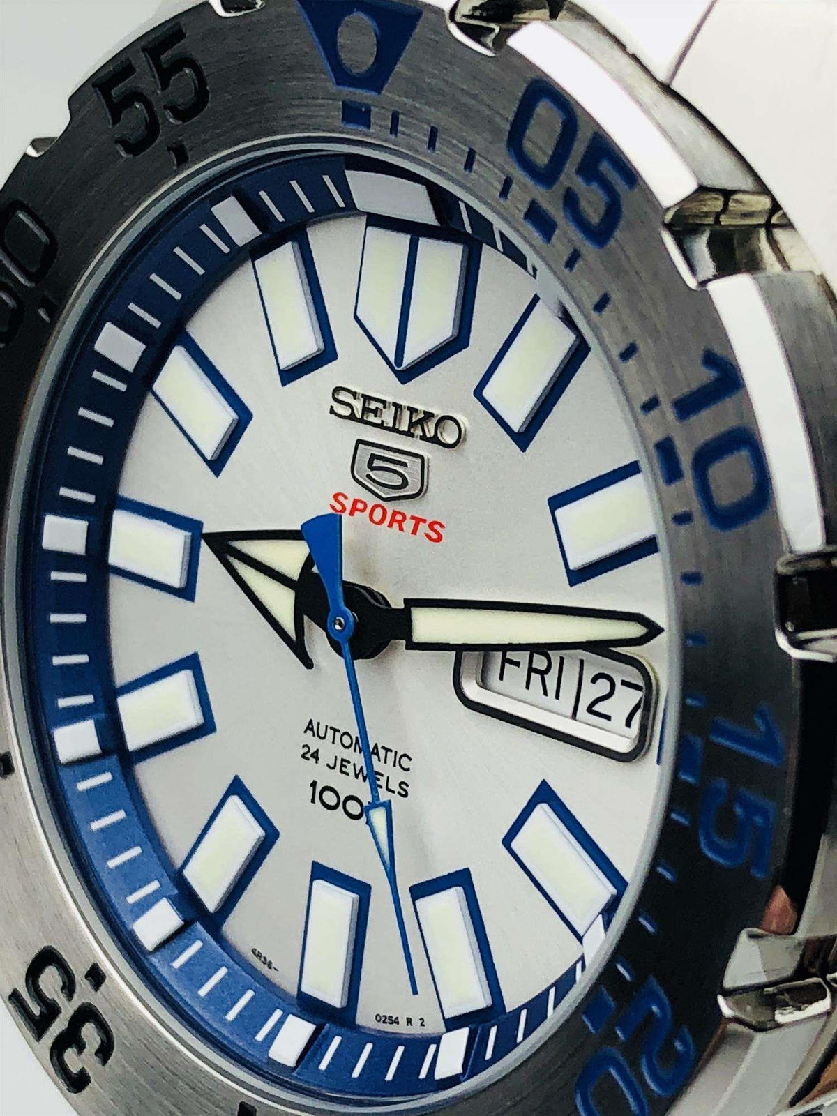 Stainless steel men’s watch with white dial, blue hour markers, and date window