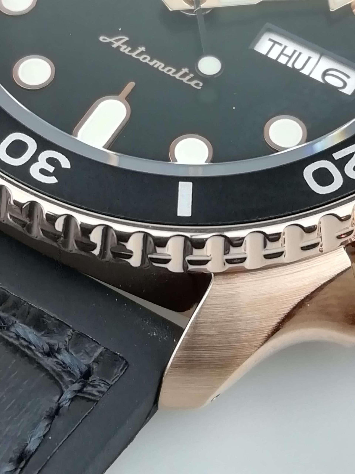 Seiko 5 watch close-up of bezel teeth and black leather strap