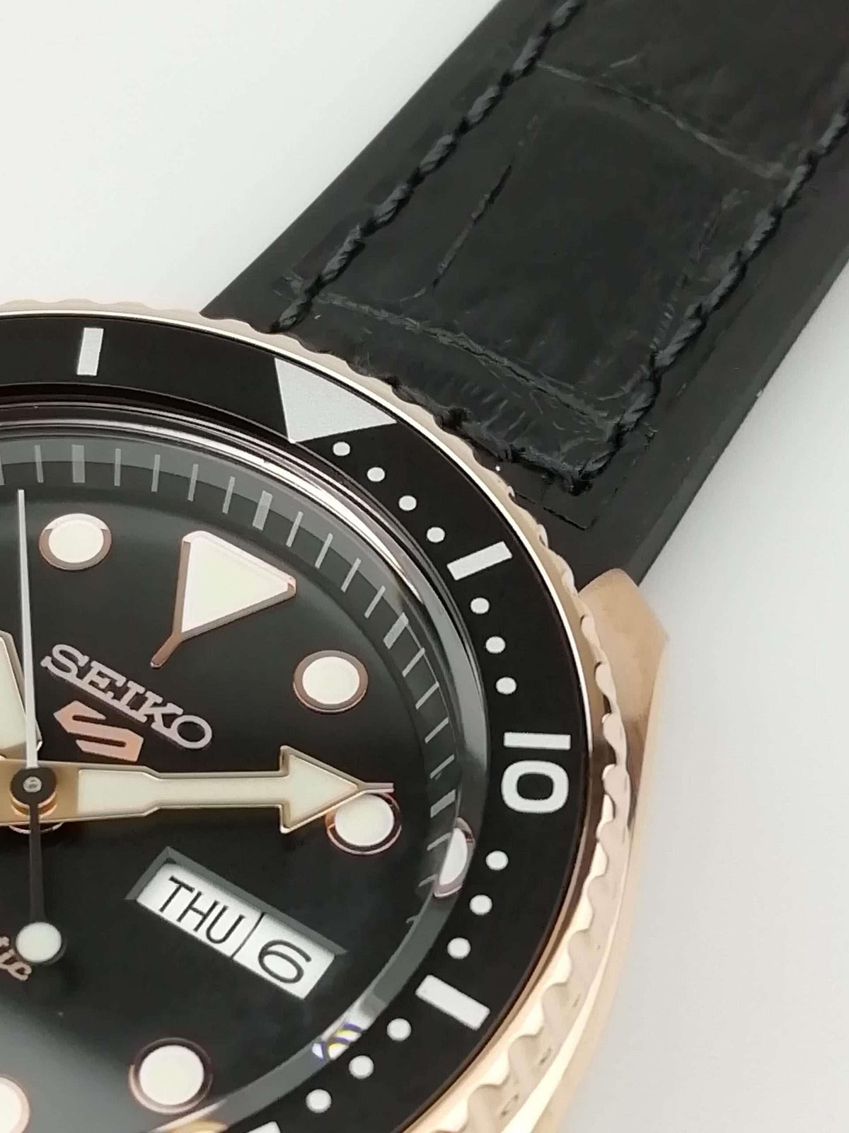Seiko 5 watch close-up of black dial, indices, and date window