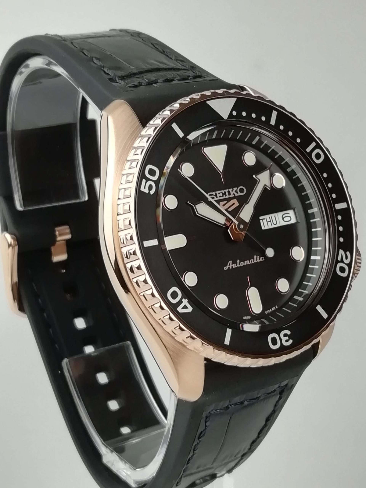 Men's Seiko 5 Sports automatic watch side profile, black dial and black strap on rose-gold tone case