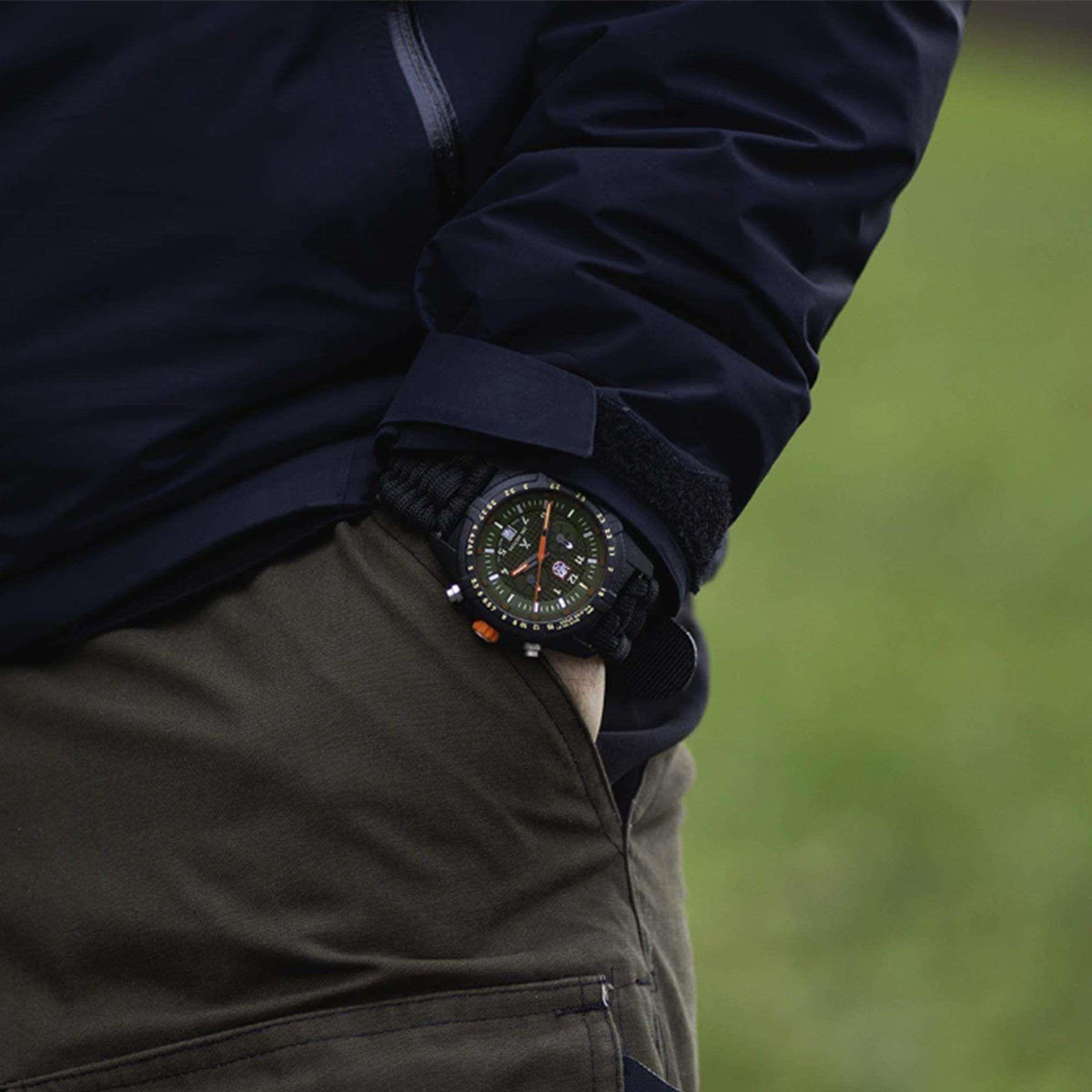 Quartz sport watch on wrist with black textile strap and green dial