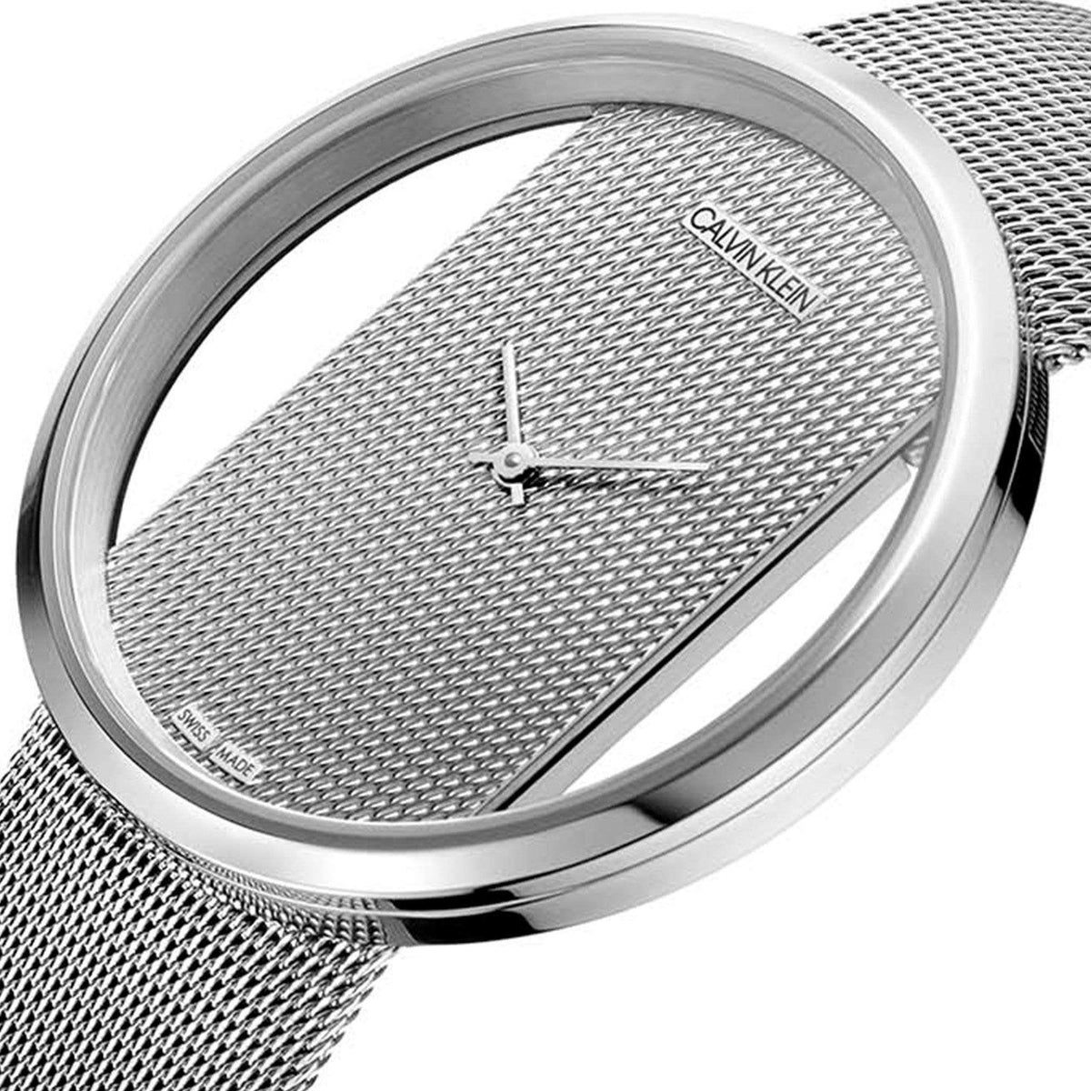 Round silver watch case with textured dial, slender hands, and stainless mesh strap