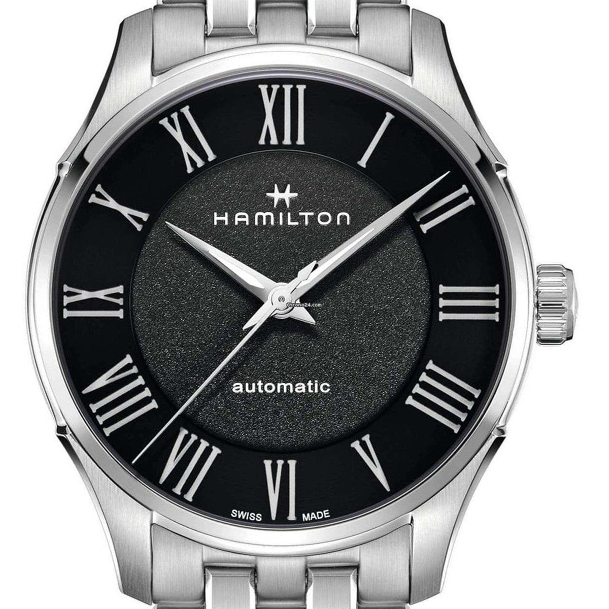 Steel automatic wristwatch close-up: textured black dial, Roman numerals, and silver hour hands