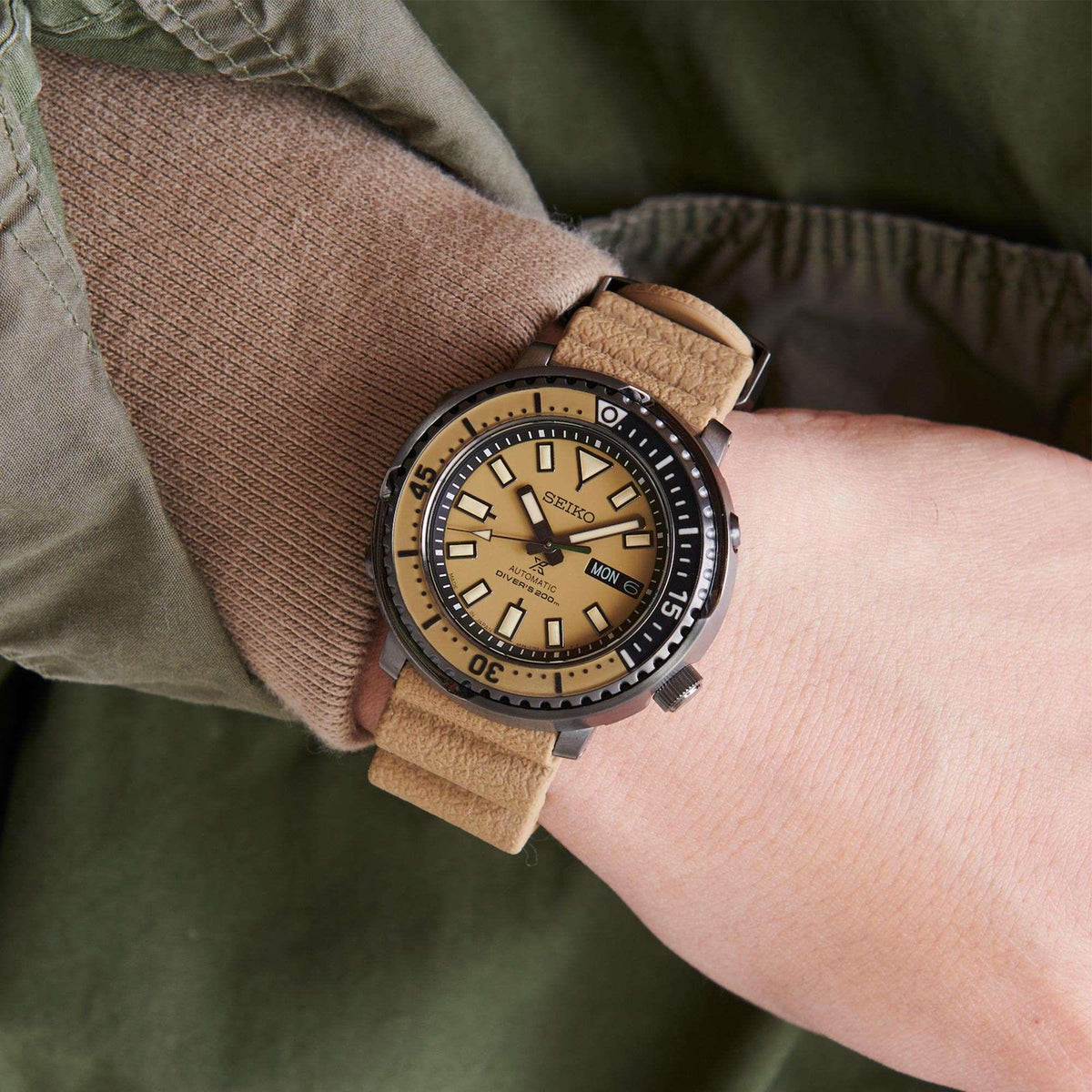Automatic diver watch on wrist, beige dial, tan leather strap with buckle, black bezel