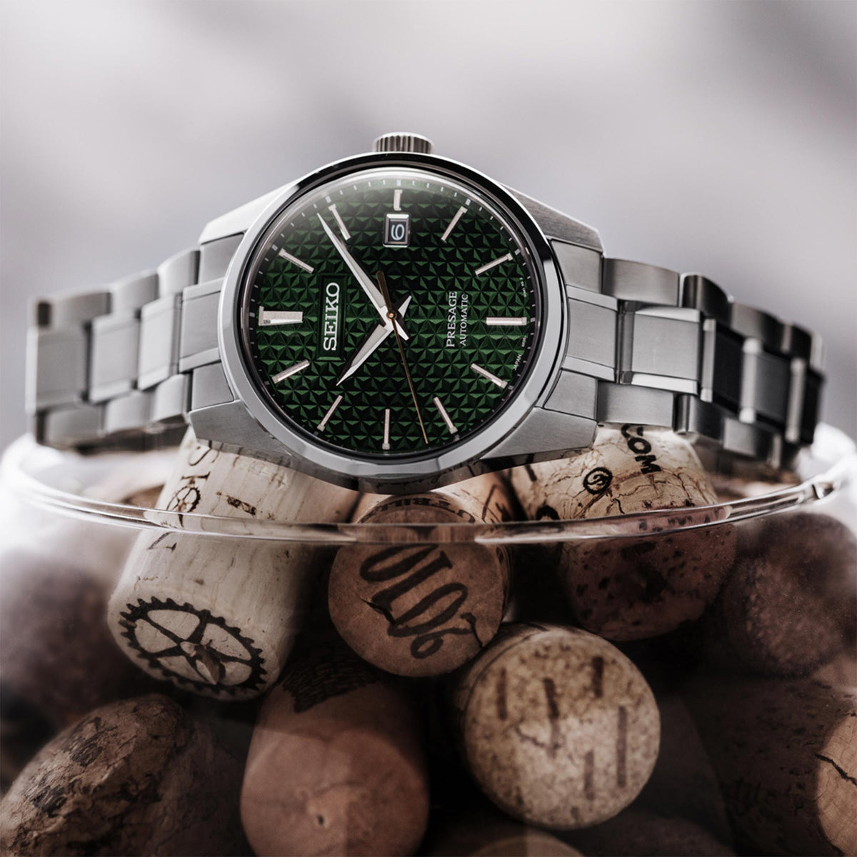Men's automatic wrist watch with textured green dial and silver bracelet, round bezel