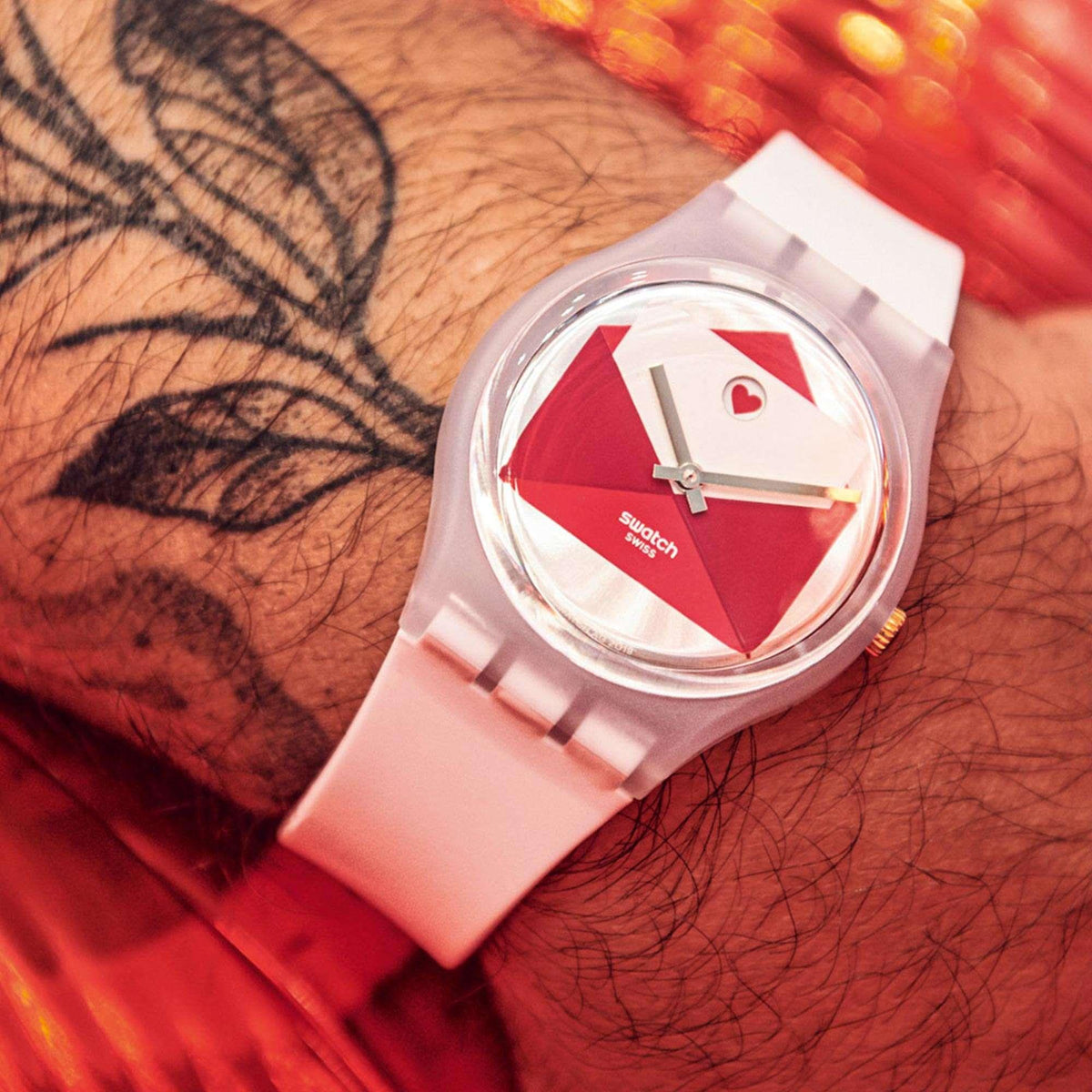 Quartz watch on wrist with white strap and red dial featuring envelope and heart