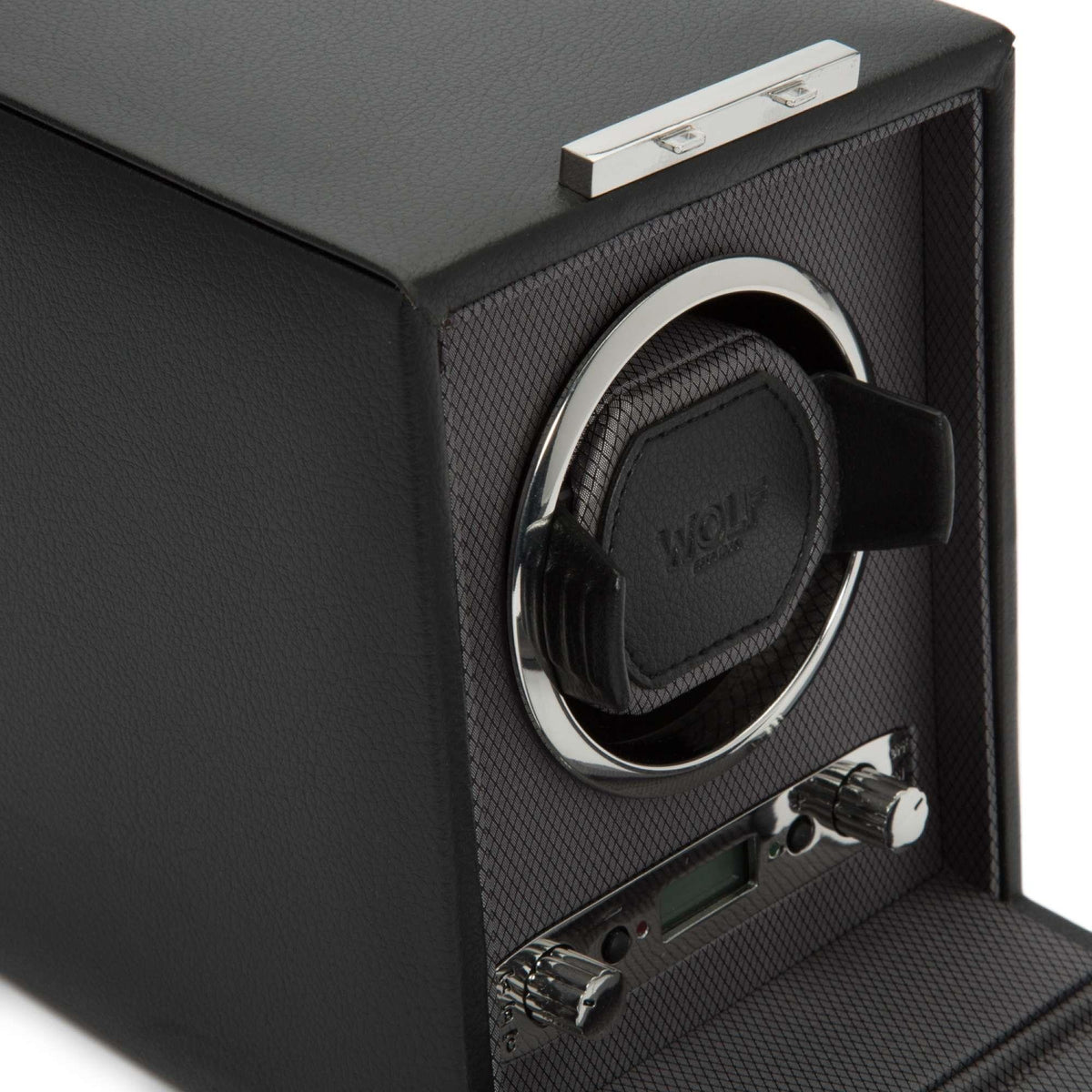 Black watch winder close detail: circular pad, chrome ring, and side control knobs.