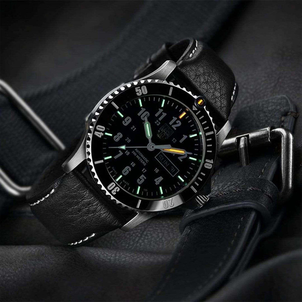 Sport watch on black leather strap with black dial and green luminous hour markers