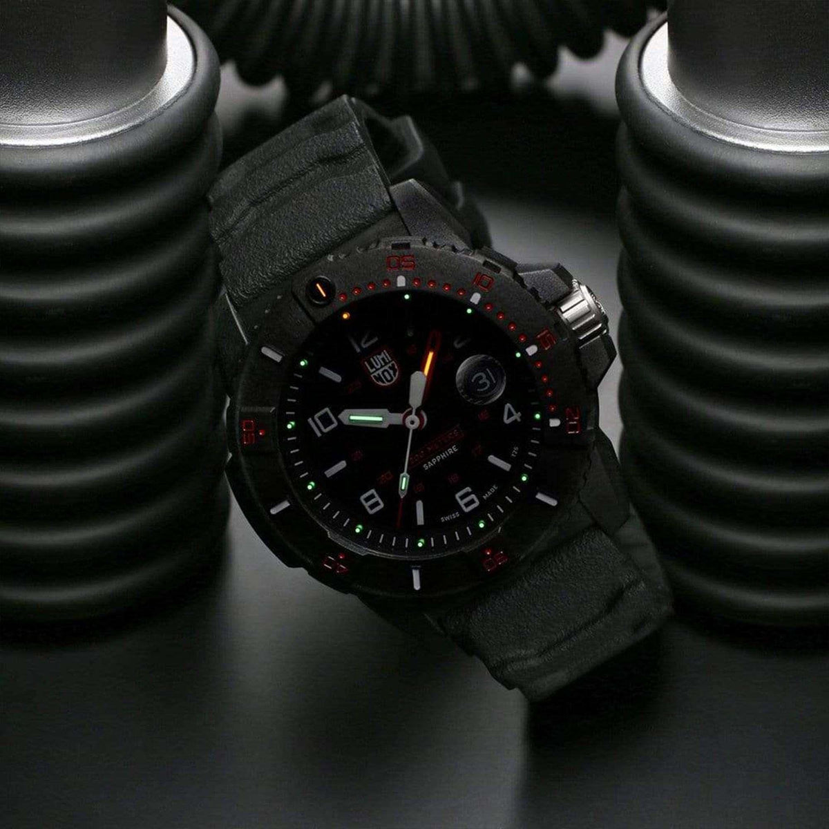 Men's dive watch with black dial, red details, and black fabric-textured rubber strap