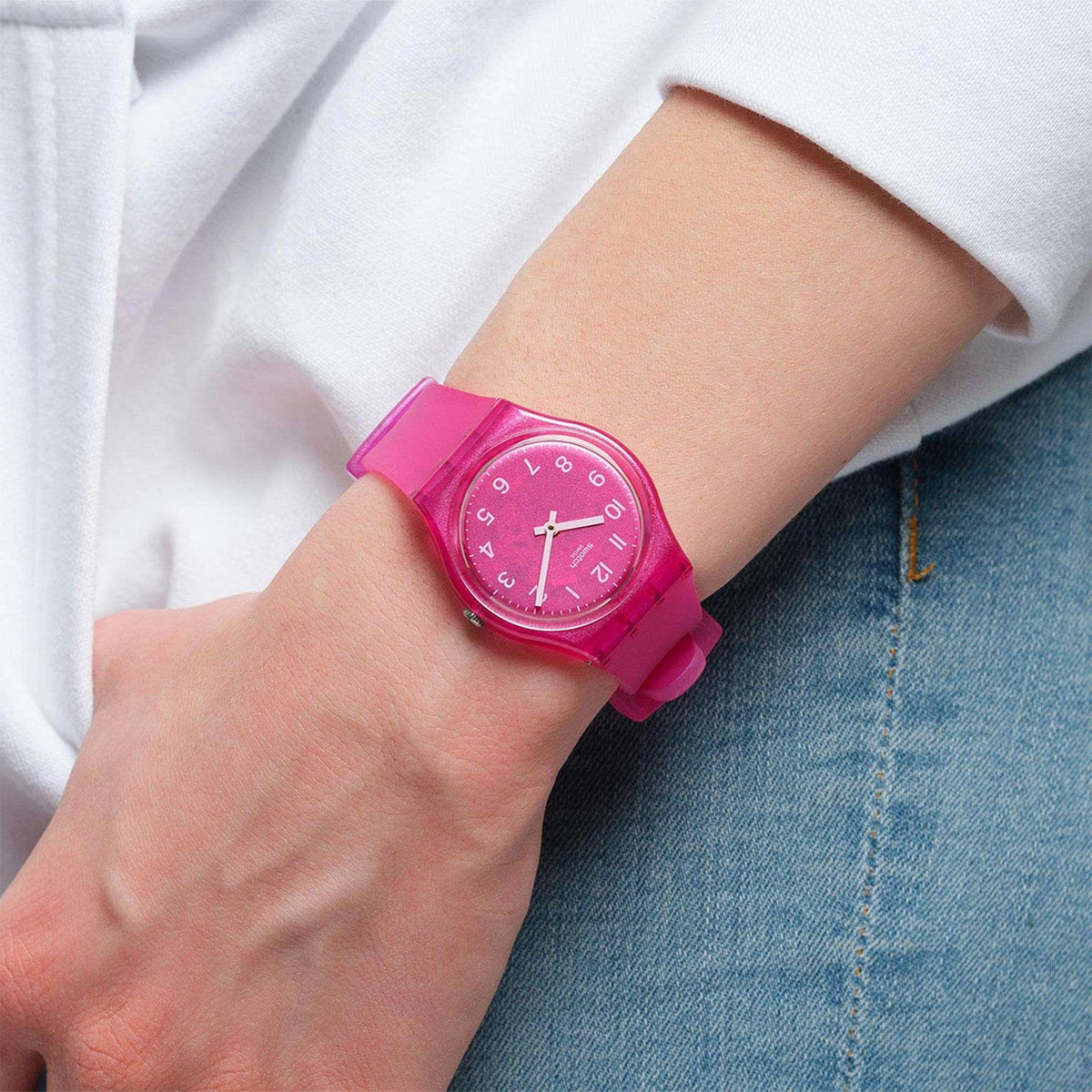 Pink dial watch on wrist with white markers and pink silicone band