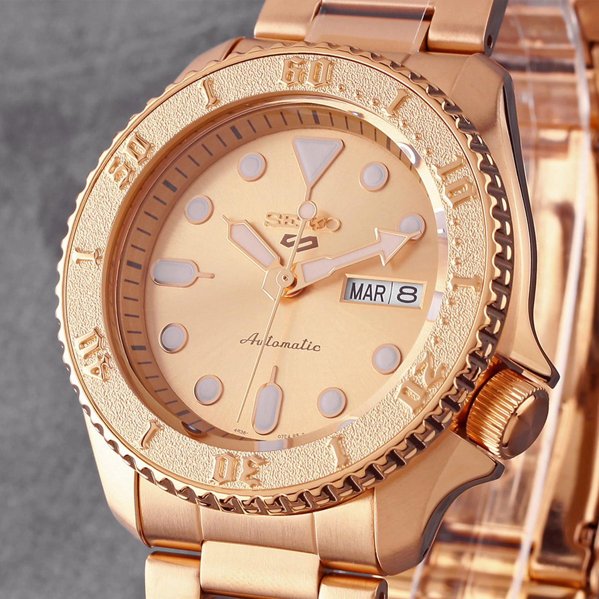 Rose gold automatic watch close-up with peach dial and date window (MAR 8)