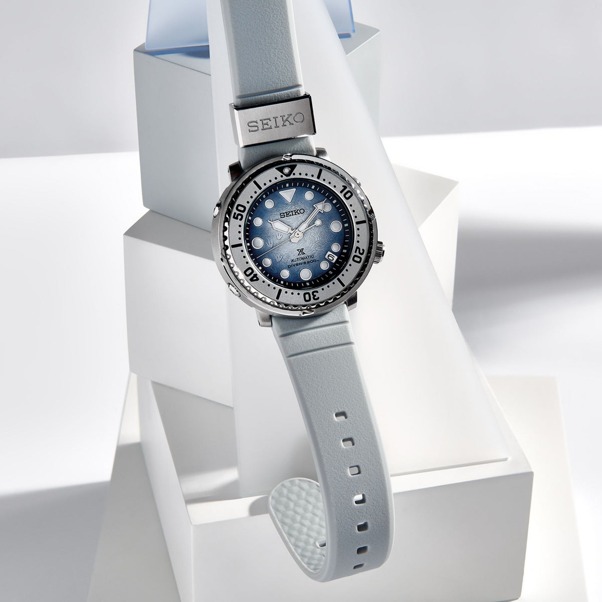 Men's diver watch with blue dial and light gray silicone strap, shown in product display