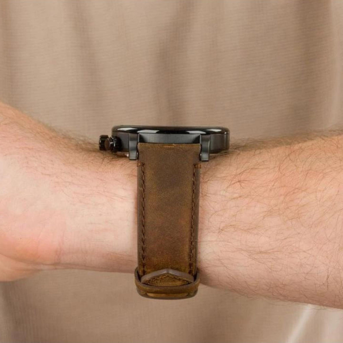 Side view of men's watch on wrist with brown leather strap and buckle