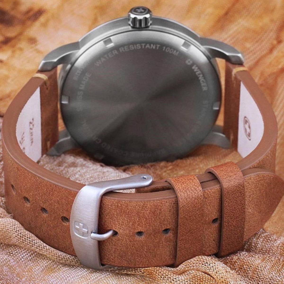 Back view of men's watch case with water-resistant text and brown leather strap buckle