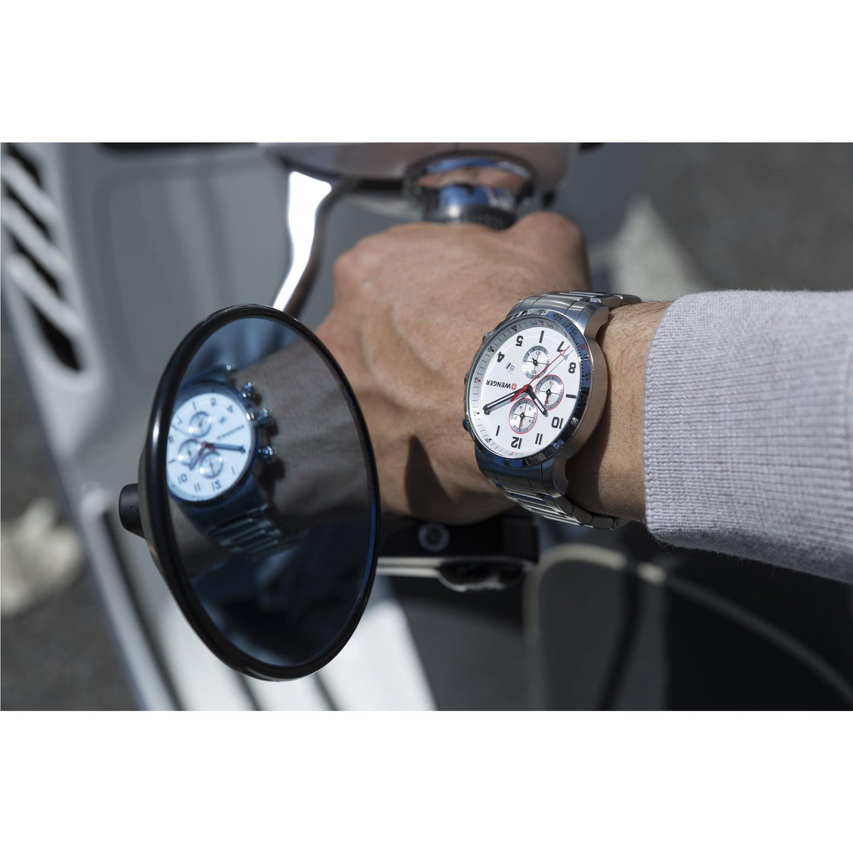 Wenger chronograph watch worn on wrist, silver dial and steel bracelet, side profile