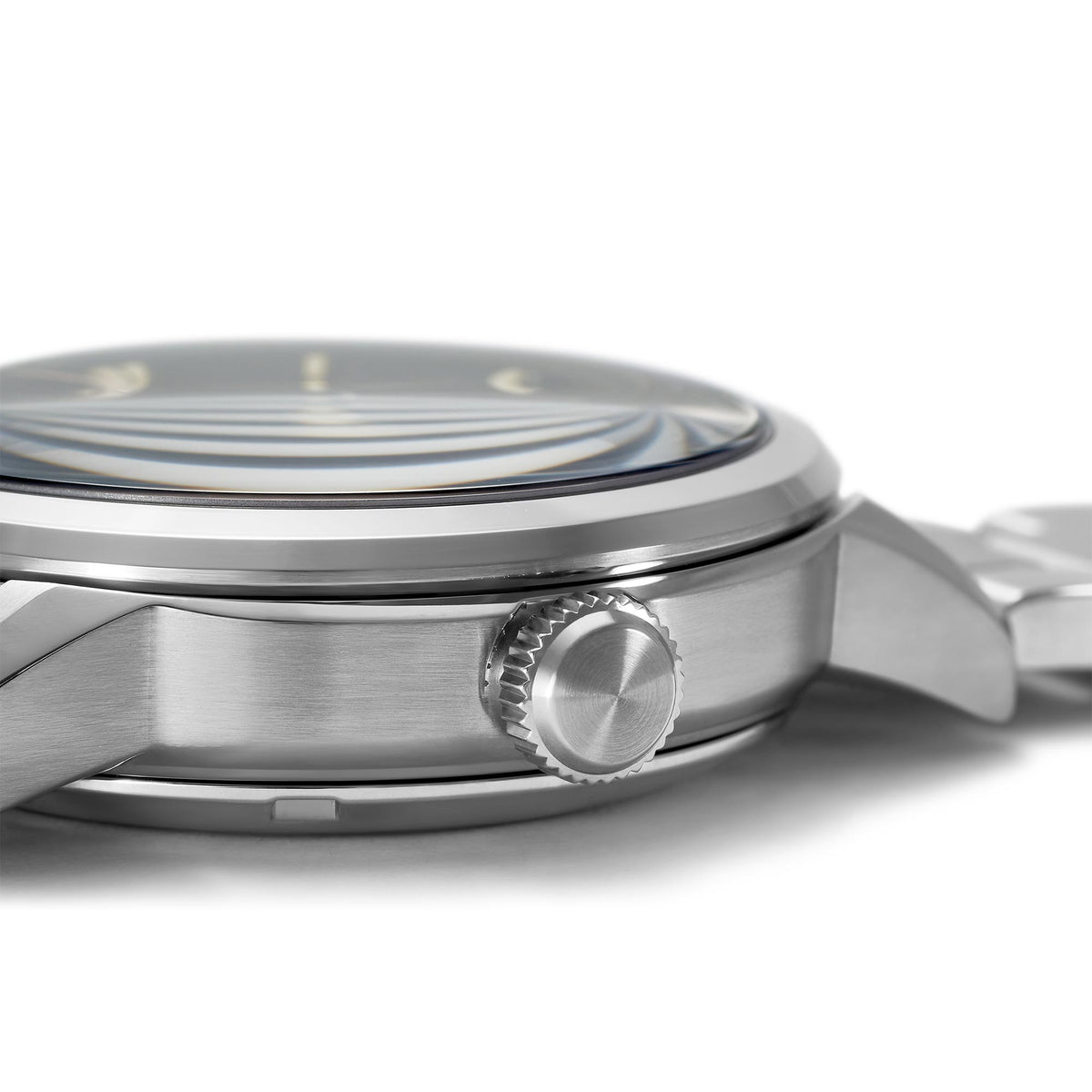 Stainless steel watch case close-up with crown and ridged bezel edge