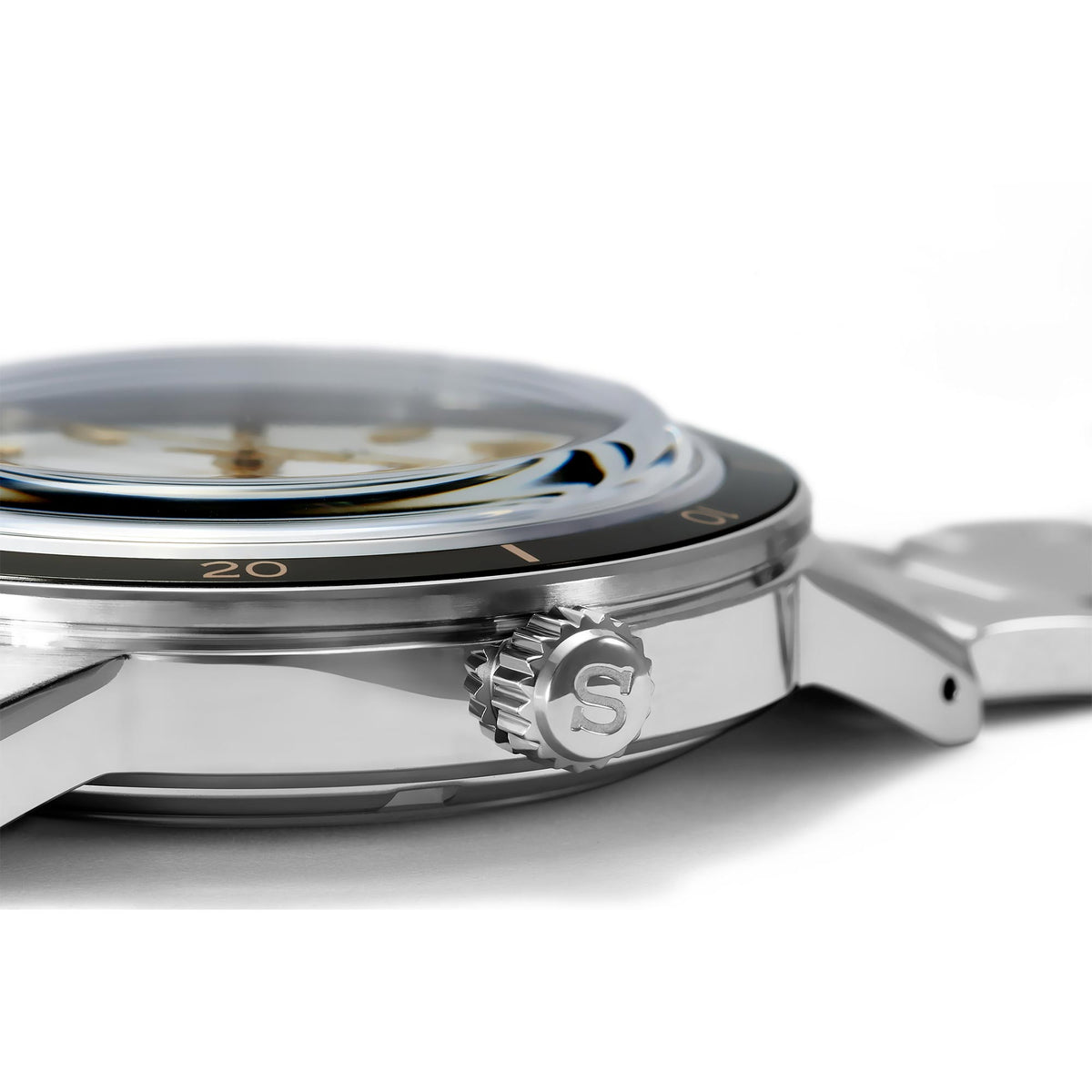 Stainless-steel watch case edge with engraved S emblem and visible crown
