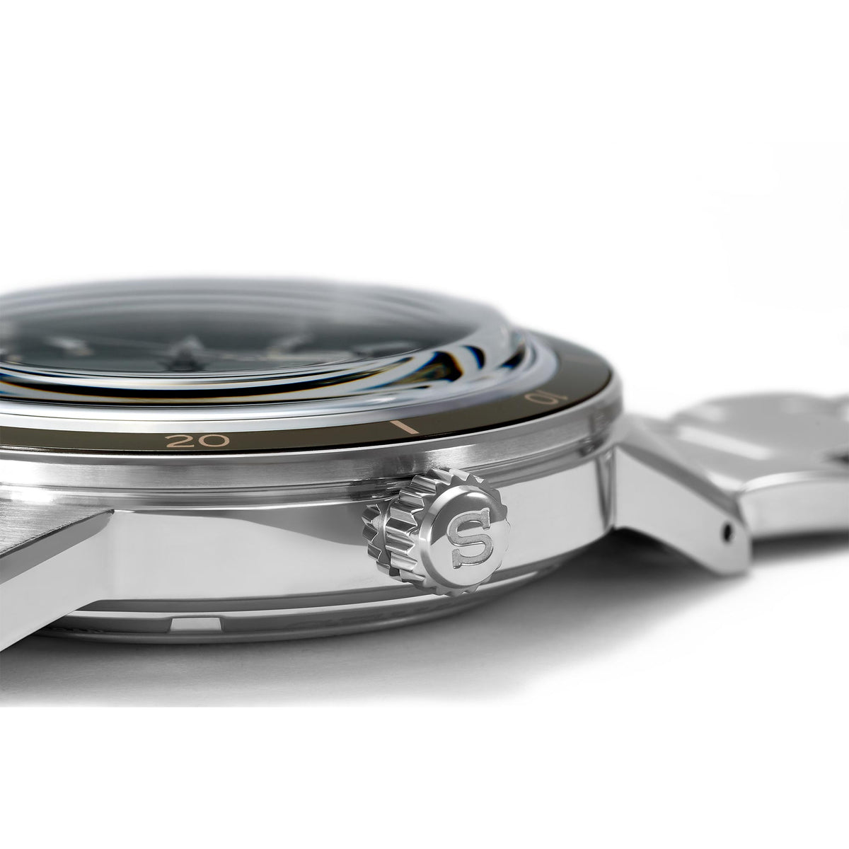 Stainless steel watch case side close-up with bezel numbers and crown