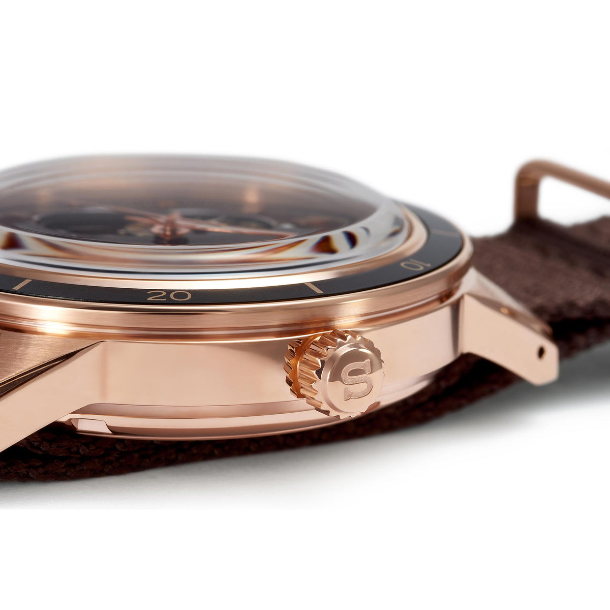 Men's automatic watch case side with crown detail and brown NATO strap, rose-gold tone
