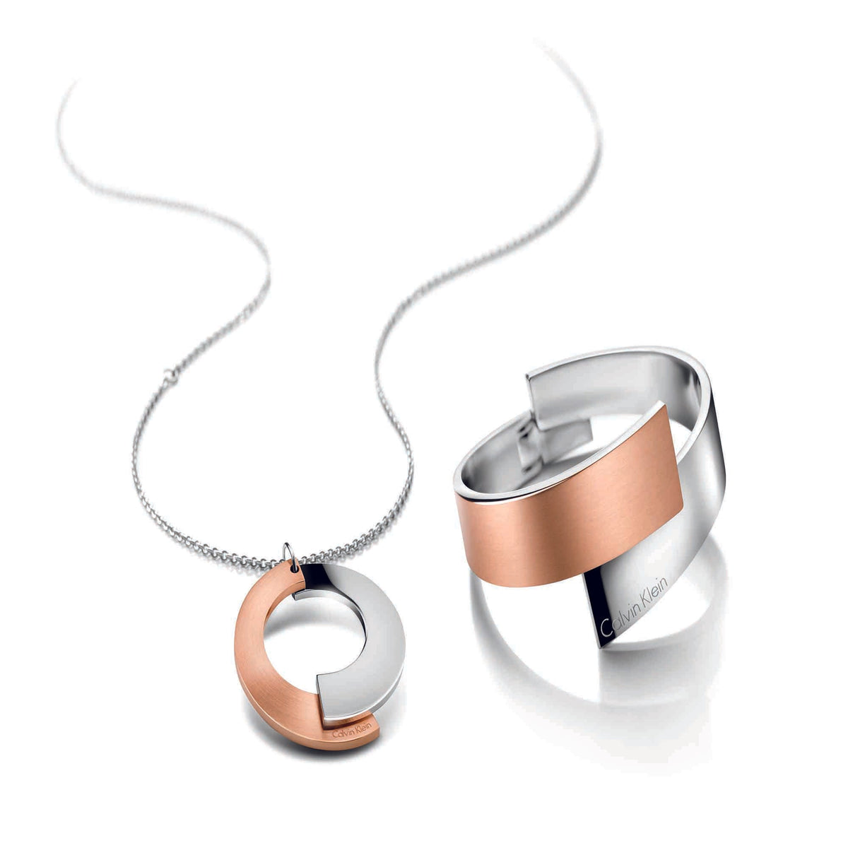 Rose gold and stainless steel pendant necklace with circular charm on a silver chain