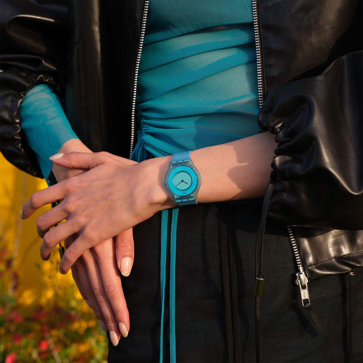 Quartz watch on wrist with teal silicone strap and blue dial.