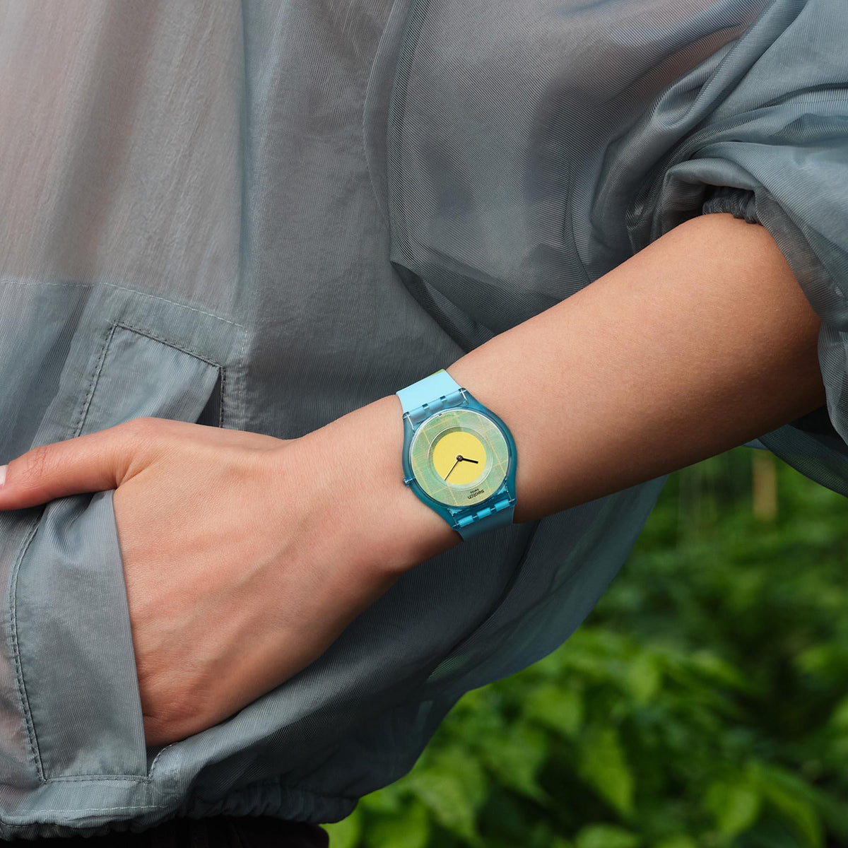 Quartz watch on wrist with light blue silicone strap and yellow dial