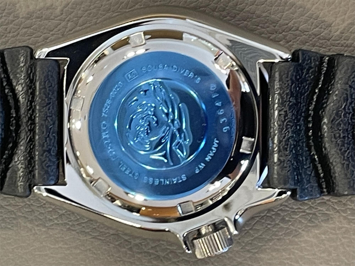 Seiko Diver’s Pepsi mens watch SKX009J1 caseback, with a silver metal casing on a textured surface