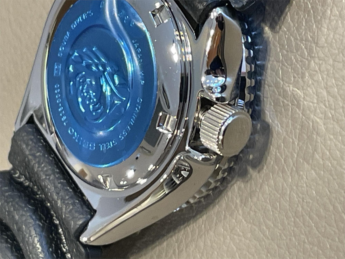 Close-up of Seiko Diver’s Pepsi mens watch SKX009J1 caseback on a beige background