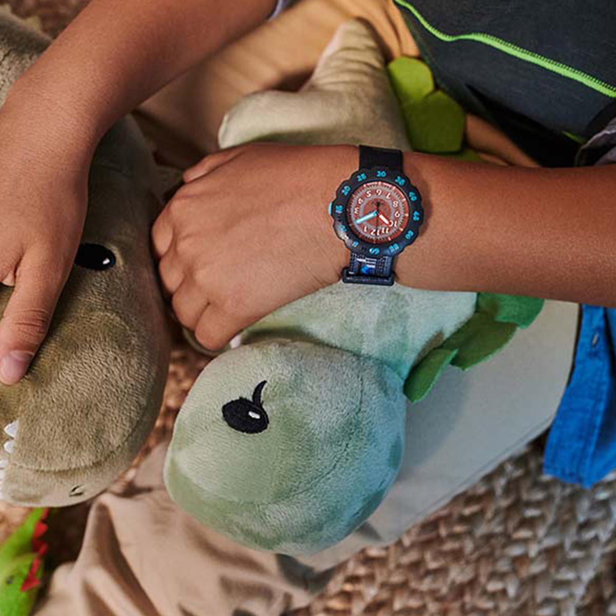 Childrens watch worn on wrist with blue dial and black strap featuring gray cloud pattern