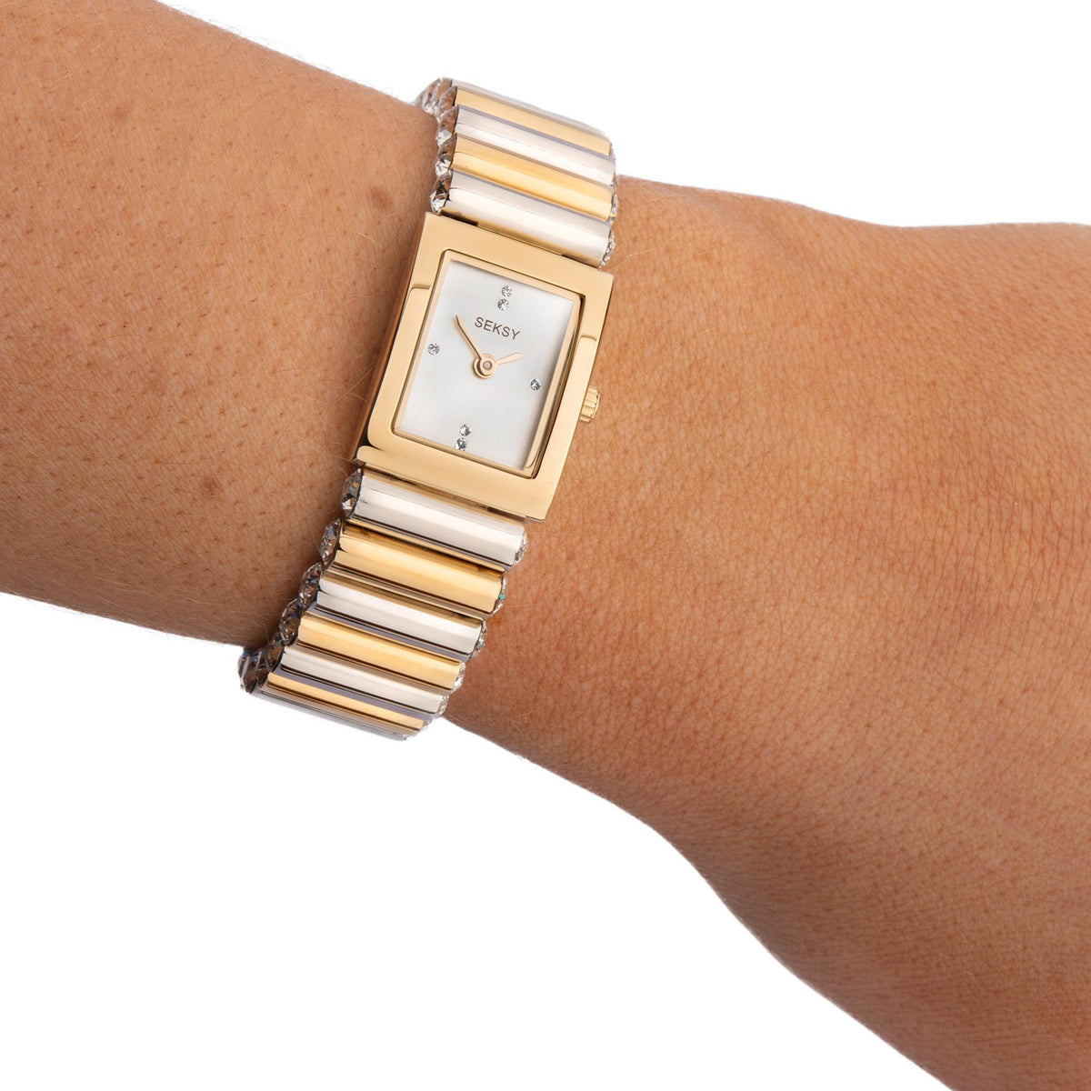 Two-tone ladies watch on wrist with rectangular case, silver dial, and gold/silver bracelet