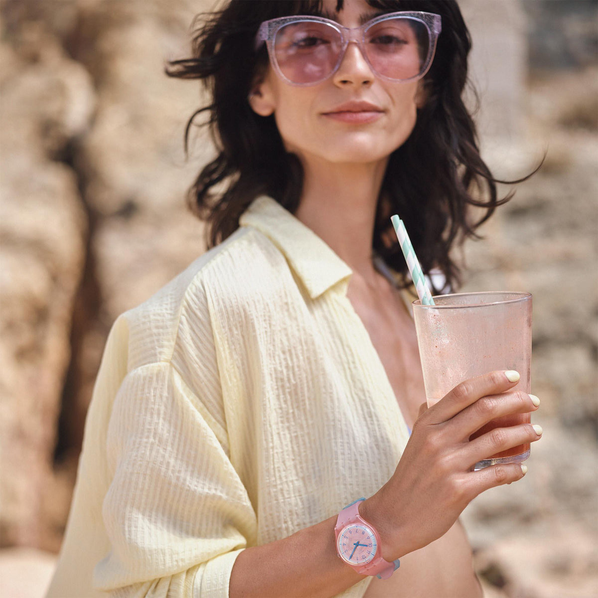 Pink silicone strap quartz watch on wrist with pink dial and blue hands
