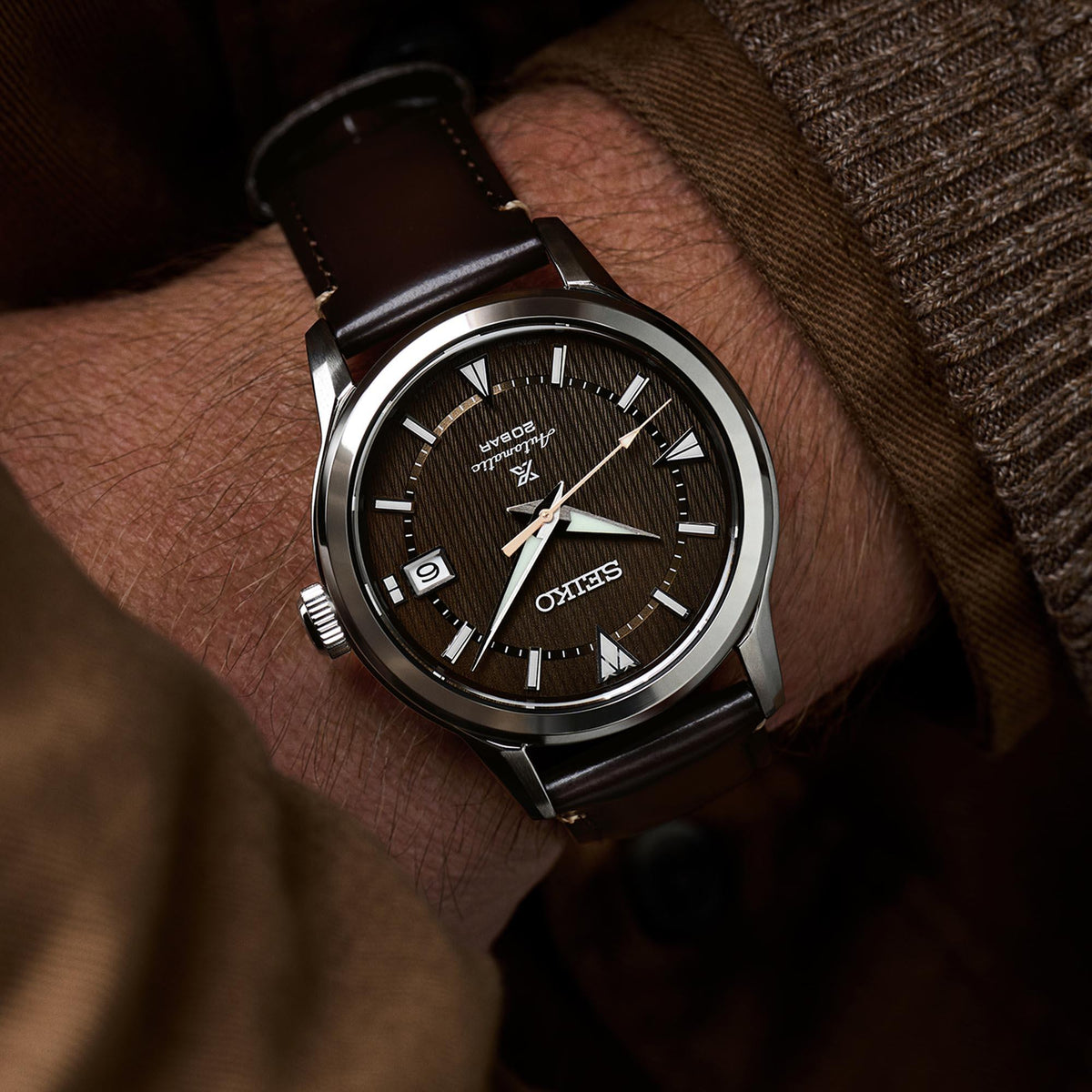 Men's automatic wristwatch with brown dial, dark brown leather strap, and stainless case.