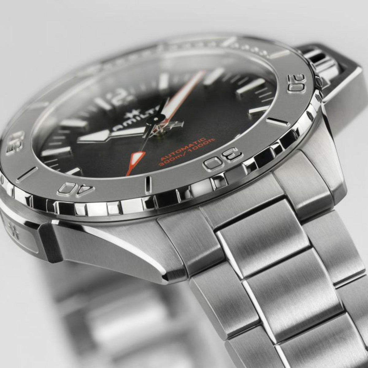 Hamilton men’s steel watch showing black dial, rotating bezel markings, and crown detail