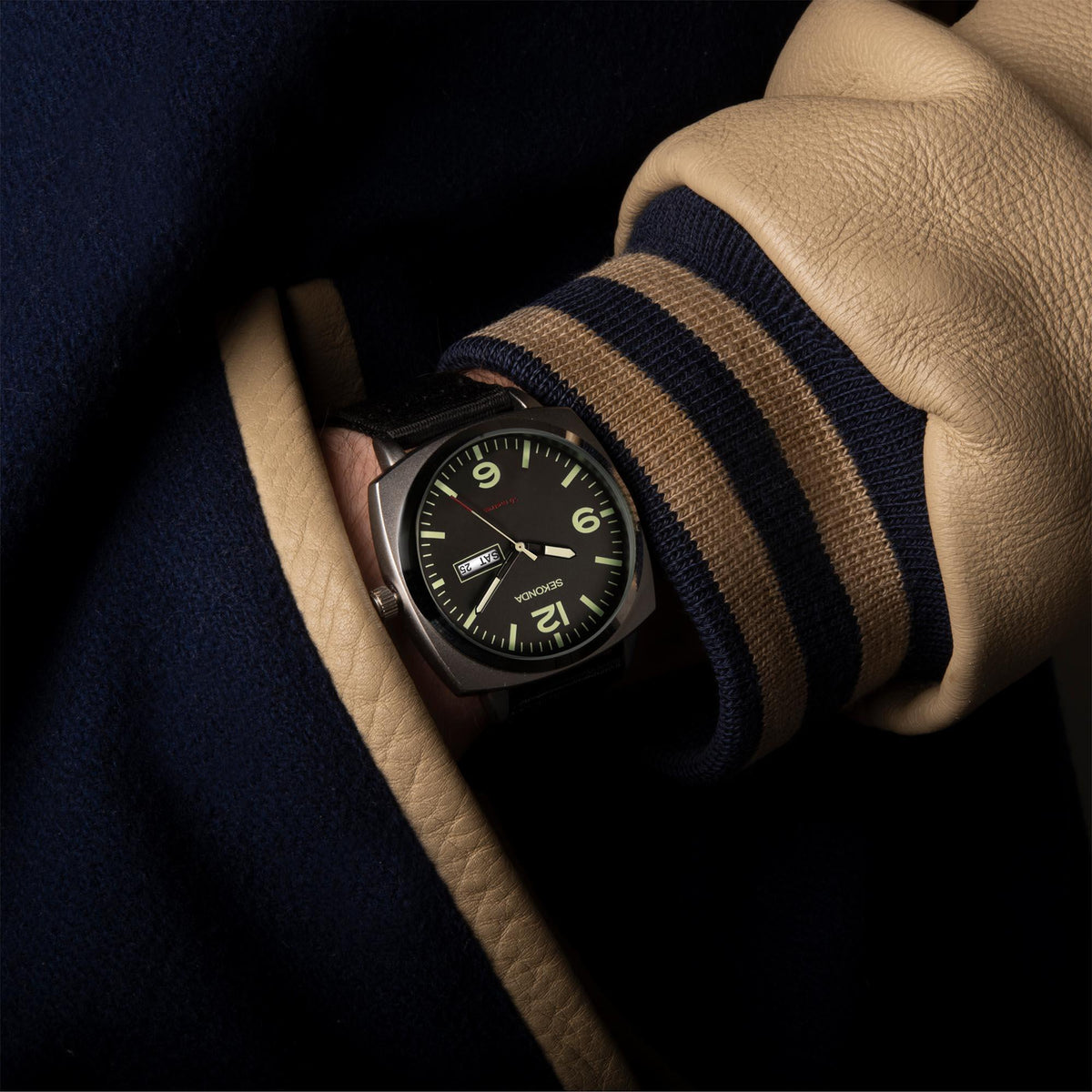 Men's black dial wristwatch on striped fabric strap, visible day-date window